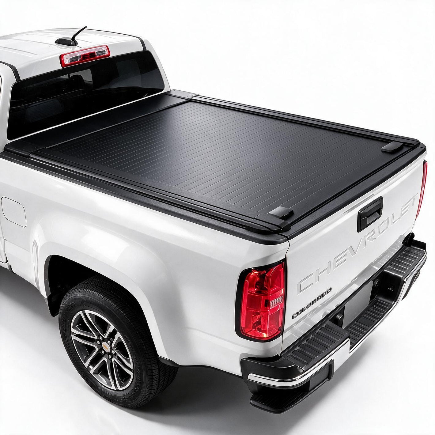 A black retractable truck bed cover installed on the bed of a white Chevrolet pickup truck, shown from a rear three-quarter angle against a plain white background.