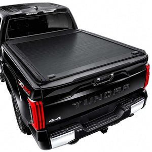 Black retractable bed cover installed on a black Tundra pickup truck, shown from a rear three-quarter angle against a white background.