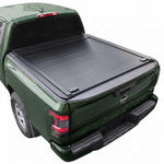 A black Frontier 6ft truck bed cover installed on the bed of a dark green pickup truck, shown from a rear three-quarter angle against a plain white background.