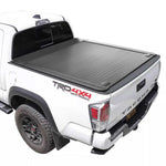 White Toyota Tacoma truck with a black enhanced mb tonneau cover on a white background