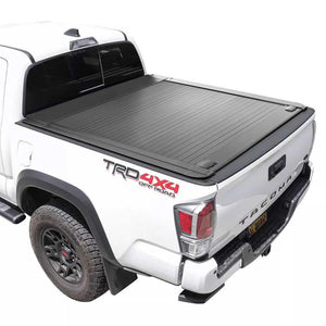White Toyota Tacoma truck with a black enhanced mb tonneau cover on a white background