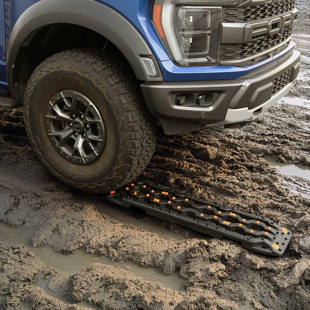 close up use of traction recovery board in a dirt road