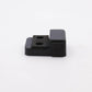 Black plastic component with two holes on a white background