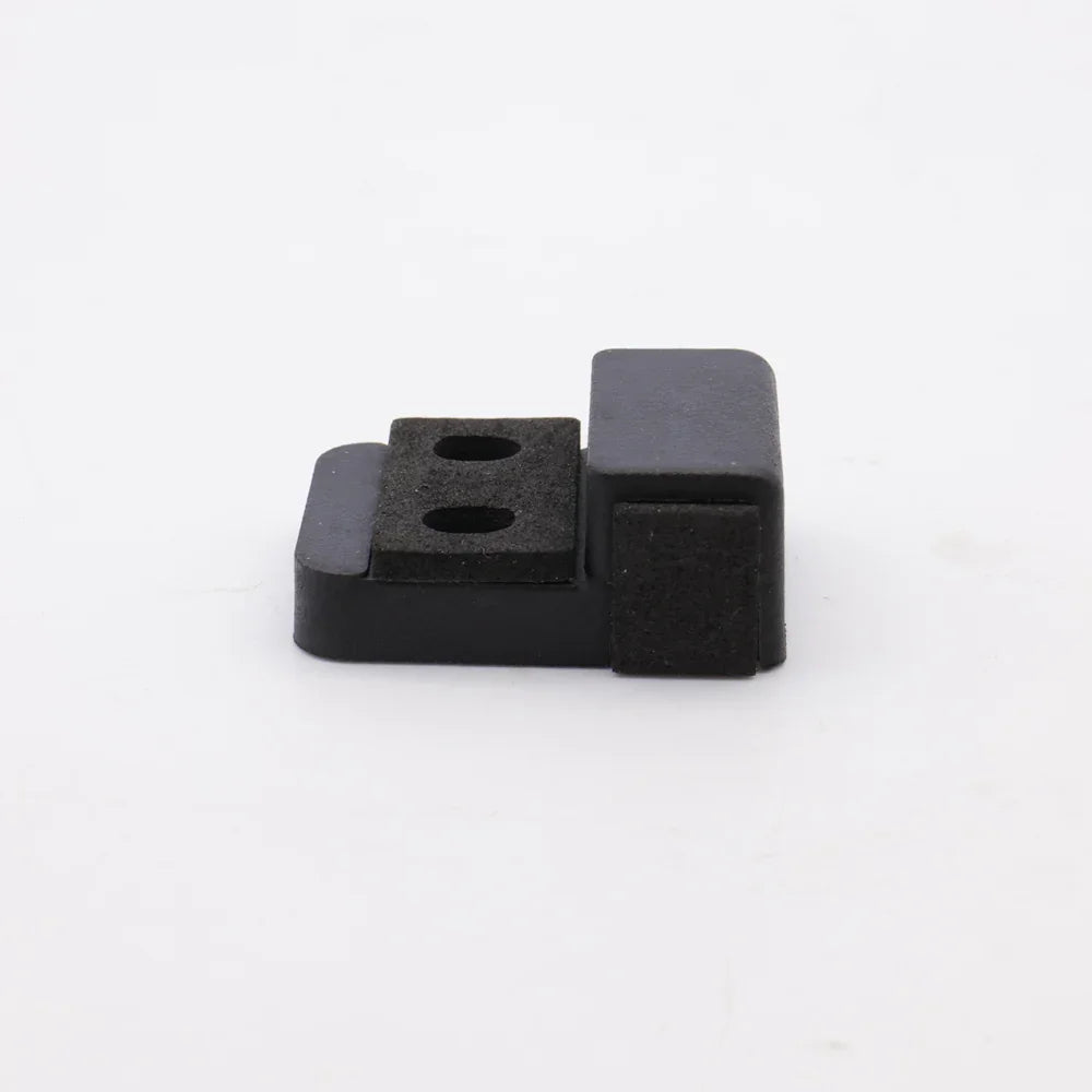 Black plastic component with two holes on a white background