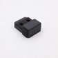 Black rectangular object with two cylindrical holes on a white background