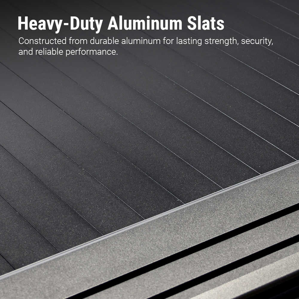 Close-up of dark gray to black aluminum slats with a metallic frame edge, overlaid with the text 'Heavy-Duty Aluminum Slats' and a descriptive feature callout.