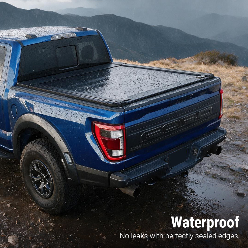 A blue Ford pickup truck parked outdoors on a rocky mountain trail, showing a black tonneau cover over the bed. Text in the lower right reads 'Waterproof' and 'No leaks with perfectly sealed edges.