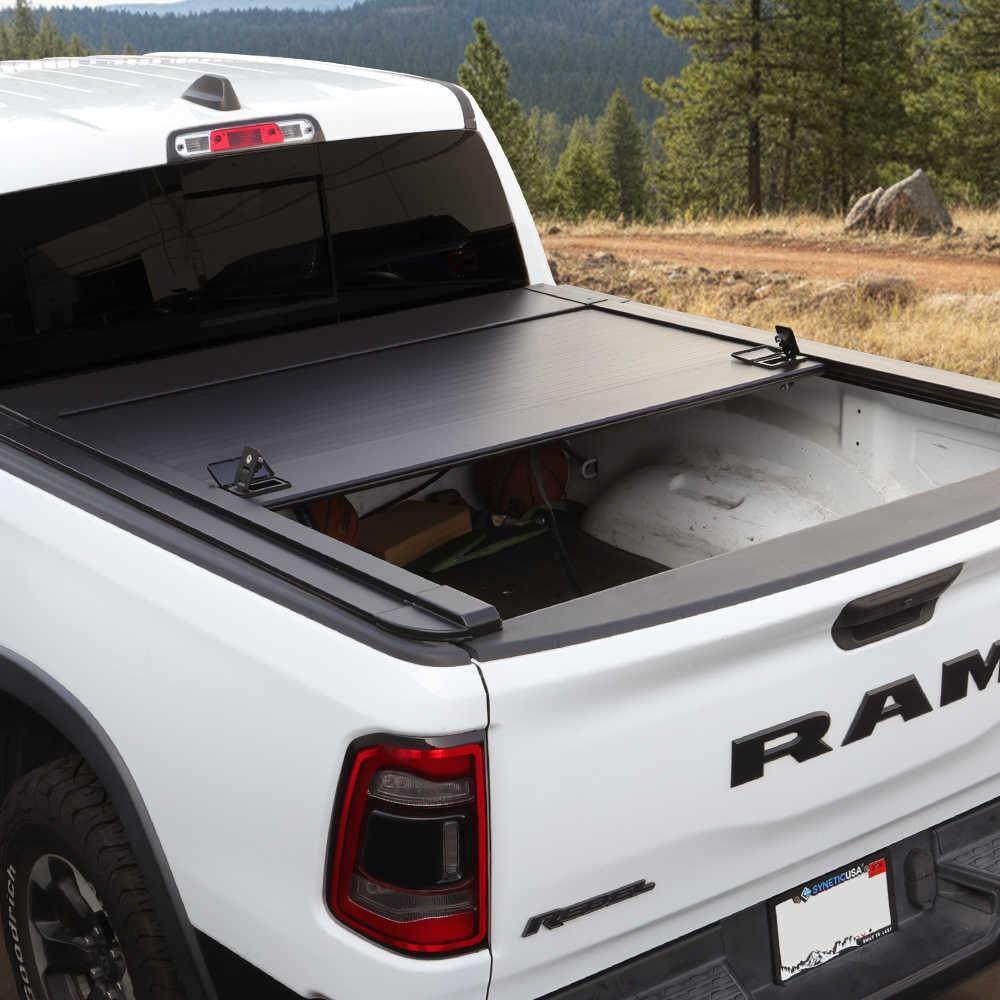 White Ram truck with a tonneau cover in a natural setting