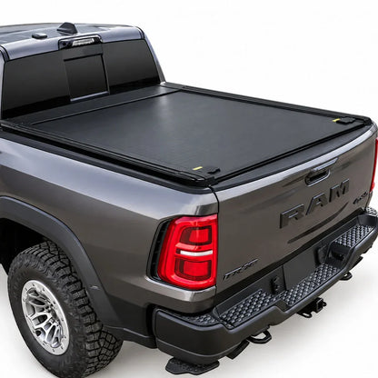 A black roll-up truck bed cover installed on the bed of a dark gray Ram pickup truck, shown from a rear three-quarter angle against a white studio background.