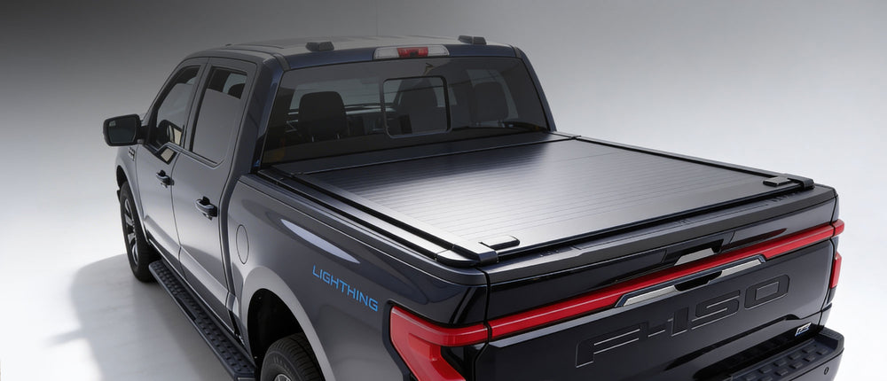 Gray pickup truck with a black tonneau cover on a white background