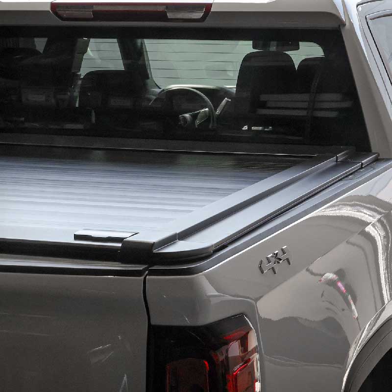 Truck bed with enhanced MB retractable tonneau cover and a visible brand logo.