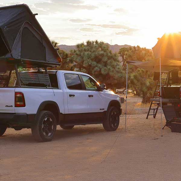 White truck with a rooftop tent in a desert camping setting