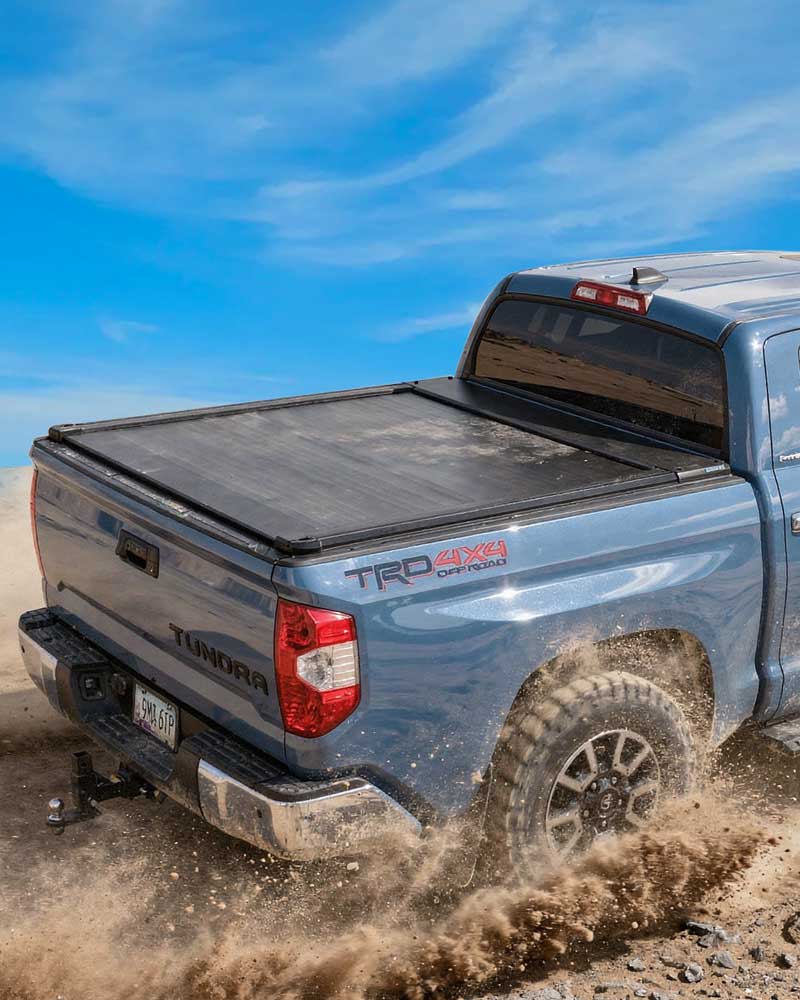 Blue Toyota Tundra truck with a tonneau cover on a dirt road, promoting Prime Day sale.