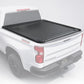 A black tonneau cover for a pickup truck bed, shown installed on the bed of a white pickup truck against a plain white background.