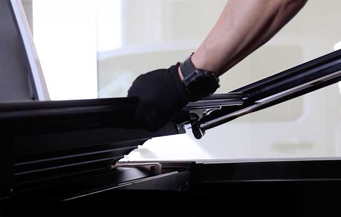Person sliding rails into tonneau cover