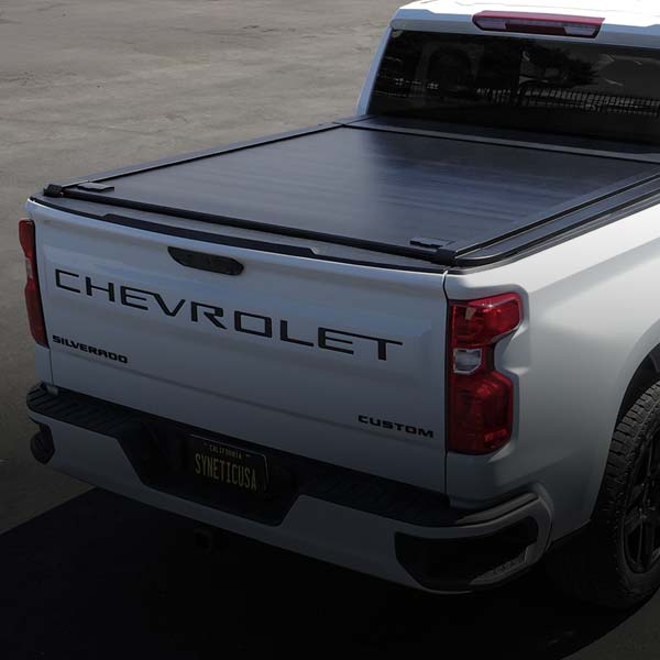 Back view of a white Chevrolet Silverado truck with a tonneau cover.
